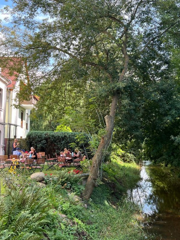 Parthe-Cafe in Zweenfurth an der Parthe. Ein Ausschnitt der Café Stühle und der Parthe, die am Kontorat vorbei fließt